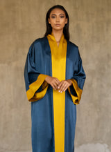 Load image into Gallery viewer, Front detail: Quarzia signature Kimono has wide, flowing sleeves and it's handcrafted from pure silk satin. As Japanese style' kimono  it is open under the arms. A bold contrast color border on the cuffs and on the front, together with the same color silk belt, frame this elegant piece, ultimate in relaxed style, elegance and comfort. The batik pattern is inspired by the stillness pose of a tiger.