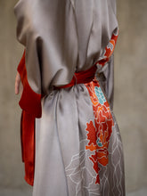 Load image into Gallery viewer, Side detail: Quarzia signature Kimono has wide, flowing sleeves and it's handcrafted from pure silk satin. As Japanese style' kimono  it is open under the arms. A bold contrast color border on the cuffs and on the front, together with the same color silk belt, frame this elegant piece, ultimate in relaxed style, elegance and comfort. The batik pattern is inspired by the beauty of imperfection in nature.