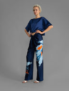 Side view. Slightly cropped boxy 100% silk stretch t-shirt in dark blue with raw cut detail on neckline and sleeves.