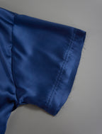 Sleeve detail. Slightly cropped boxy 100% silk stretch t-shirt in dark blue with raw cut detail on neckline and sleeves.