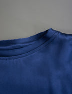 Neckline detail. Slightly cropped boxy 100% silk stretch t-shirt in dark blue with raw cut detail on neckline and sleeves.