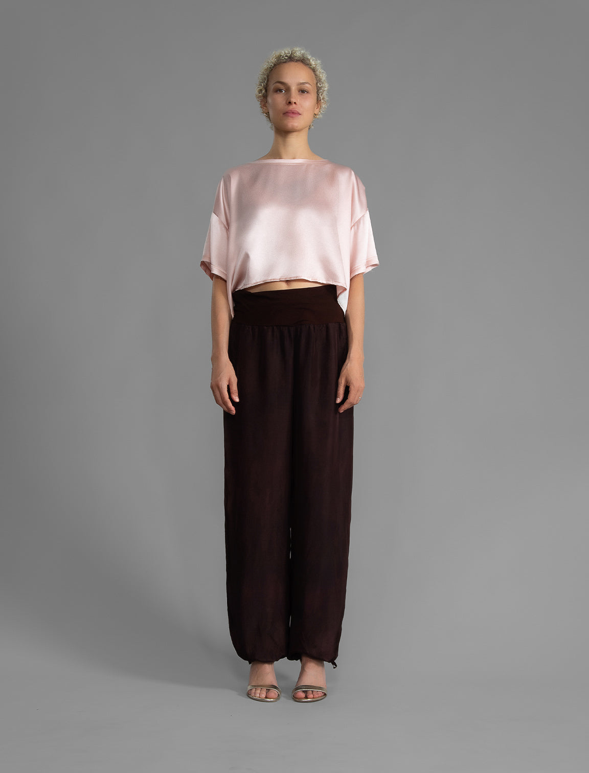Front view. Slightly cropped boxy 100% silk stretch t-shirt in soft pink with raw cut detail on neckline and sleeves.