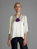 Close view. Lightweight 100% silk satin top in ivory colour, features a wide neckline with a button fastening at the back, a gently curved hemline and wide sleeves 3/4 length sleeves.