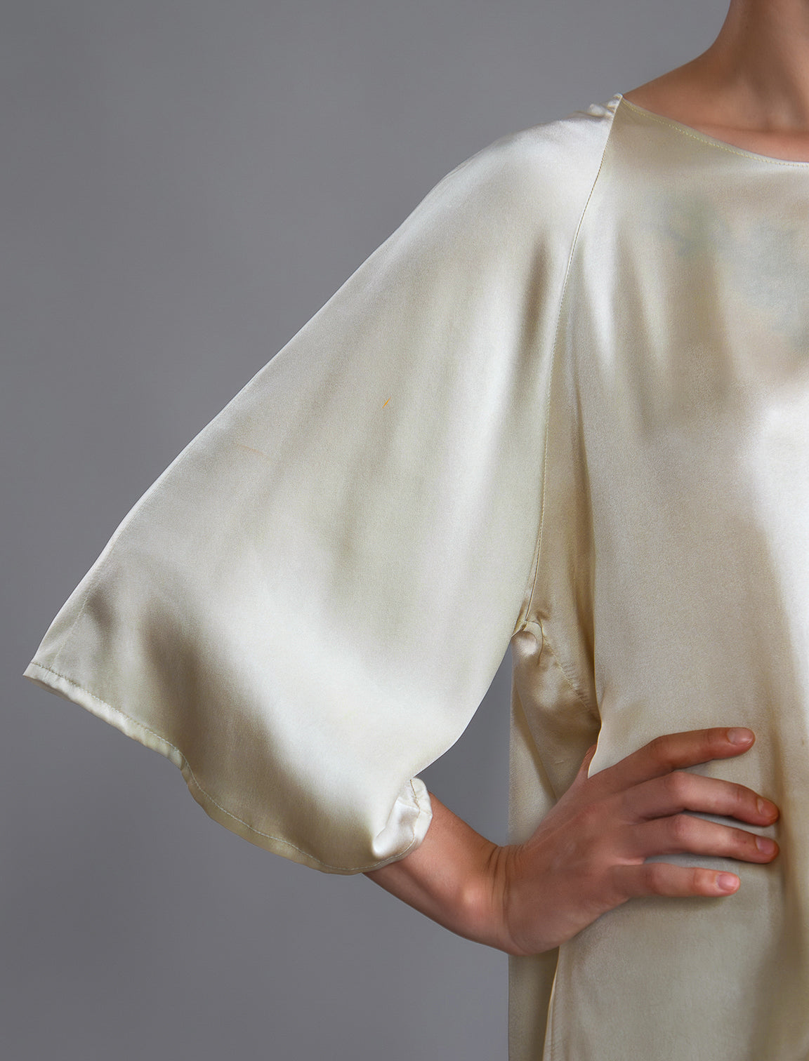 Sleeve detail 2. Lightweight 100% silk satin top in ivory colour, features a wide neckline with a button fastening at the back, a gently curved hemline and wide sleeves 3/4 length sleeves.