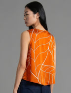 Back view. 100% silk short length stretch singlet with linear leaf motif on orange colour with open neckline and wide shoulder straps.