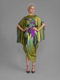 Front view. Elegant silk kaftan dress with oversized tropical leaf motif in moss green color silk, featuring flowing kimono sleeves, asymmetrical hemline, and relaxed contemporary silhouette.