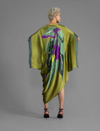 Back view. Elegant silk kaftan dress with oversized tropical leaf motif in moss green color silk, featuring flowing kimono sleeves, asymmetrical hemline, and relaxed contemporary silhouette.