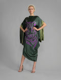 Front View. Forest green silk batik dress with bold handmade Tiger batik motif in purple, draped silhouette and artisanal craftsmanship from Bali.