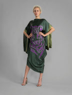Front View. Forest green silk batik dress with bold handmade Tiger batik motif in purple, draped silhouette and artisanal craftsmanship from Bali.