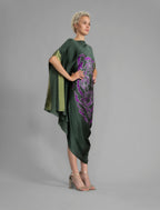 Side View. Forest green silk batik dress with bold handmade Tiger batik motif in purple, draped silhouette and artisanal craftsmanship from Bali.