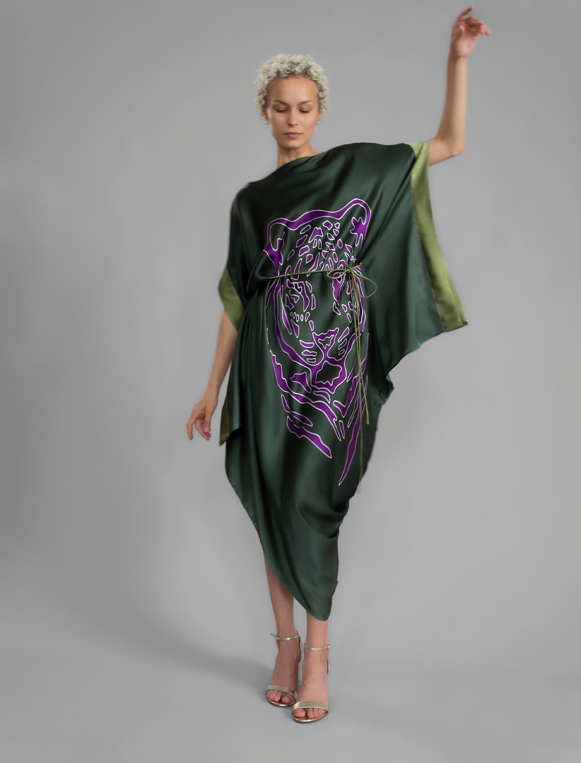 Front View with belt. Forest green silk batik dress with bold handmade Tiger batik motif in purple, draped silhouette and artisanal craftsmanship from Bali.