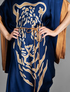 Detail view. Navy Blue silk batik dress with bold handmade Tiger batik motif in gold, draped silhouette and artisanal craftsmanship from Bali.
