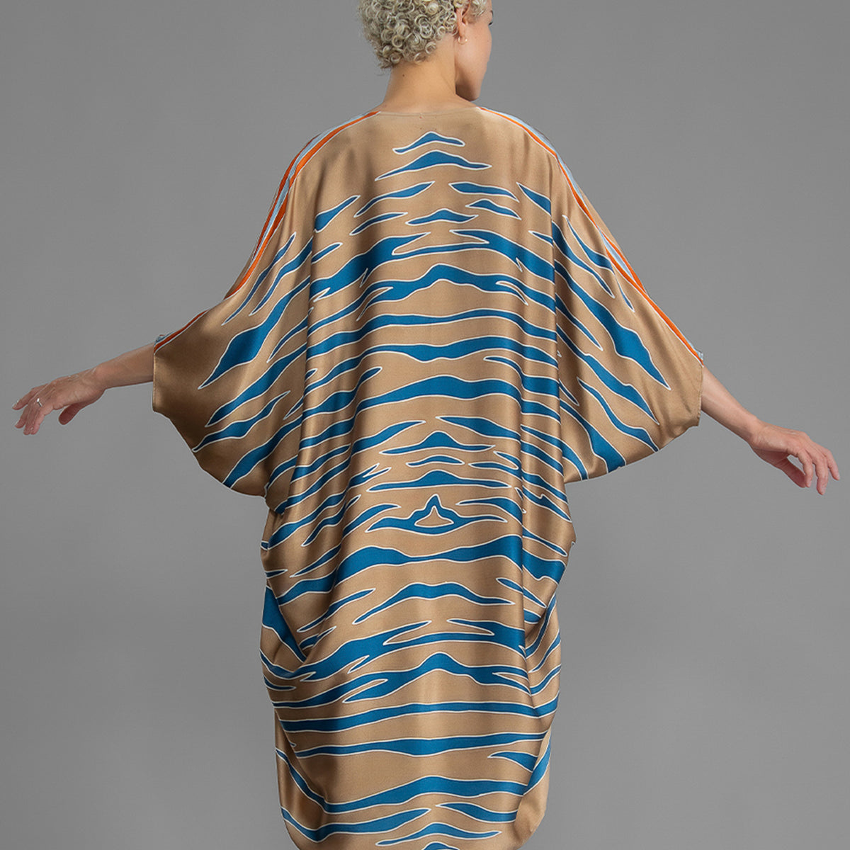 Back view of a woman in a hand-painted silk kimono with a blue Zebra pattern