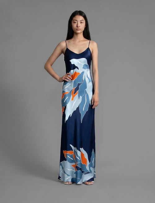Front view. Elegant long body contouring silk dress in navy blue colour. The My Jungle motif transforms natural inspiration into contemporary elegance, featuring spaghetti straps, V-neckline and a fluid contemporary silhouette.