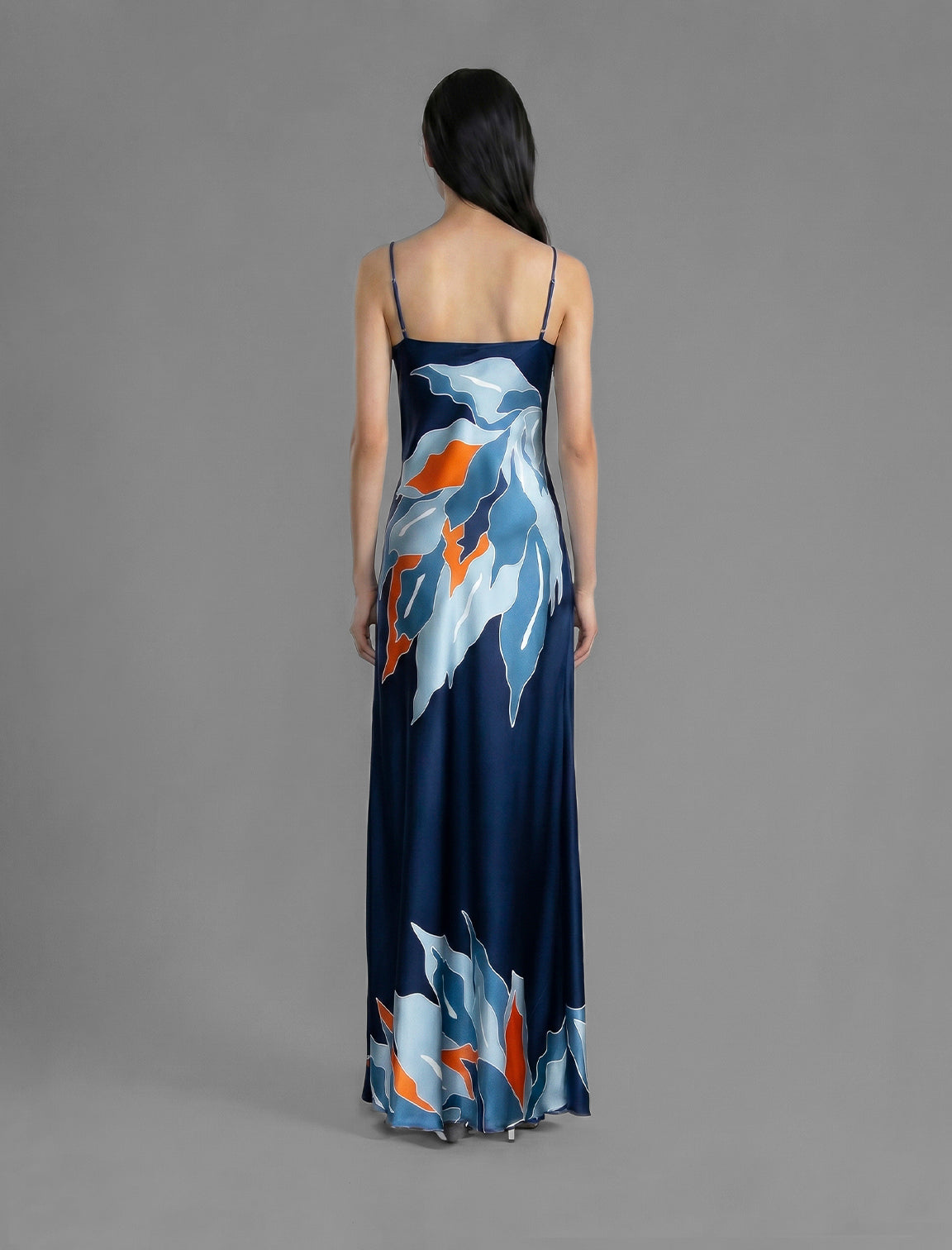Back view. Elegant long body contouring silk dress in navy blue colour. The My Jungle motif transforms natural inspiration into contemporary elegance, featuring spaghetti straps, V-neckline and a fluid contemporary silhouette.