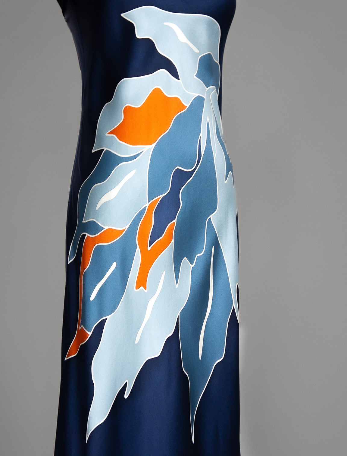 Detail view. Elegant long body contouring silk dress in navy blue colour. The My Jungle motif transforms natural inspiration into contemporary elegance, featuring spaghetti straps, V-neckline and a fluid contemporary silhouette.