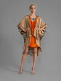 Front view. Relaxed flowing silk kaftan with graphic pale blue zebra motif on caramel colour, with orange detail, featuring 3/4 length sleeves and a voluminous silhouette.