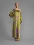 Front view without belt. Full length 100% silk tunic dress with purple macrosnake motif on moss green colour, featuring a open, wide neckline and one side split on the skirt, gathered 3/4 length sleeves with a slash opening and optional ribbon belt.