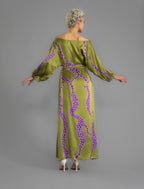 Back view with belt. Full length 100% silk tunic dress with purple macrosnake motif on moss green colour, featuring a open, wide neckline and one side split on the skirt, gathered 3/4 length sleeves with a slash opening and optional ribbon belt.