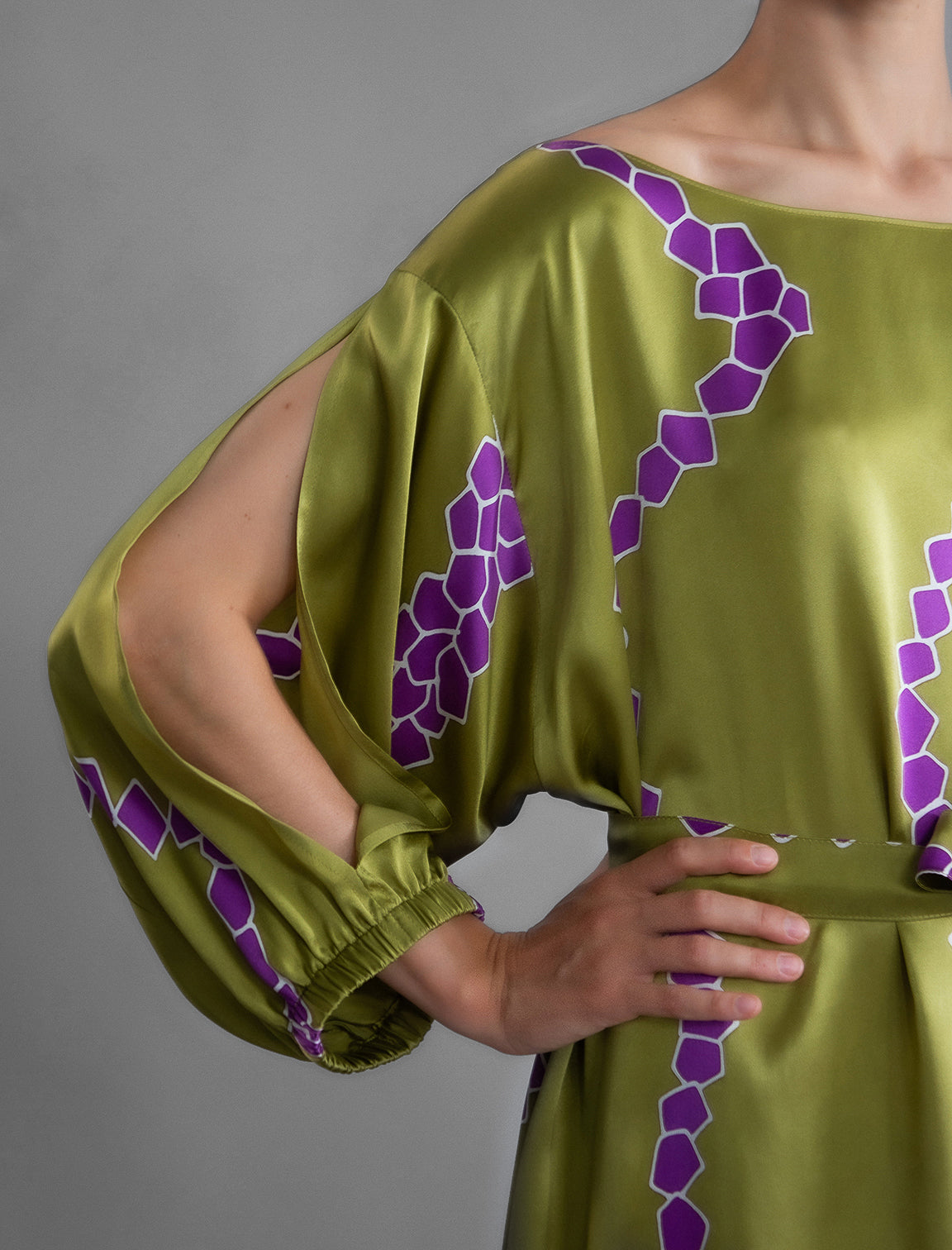 Sleeve detail. Full length 100% silk tunic dress with purple macrosnake motif on moss green colour, featuring a open, wide neckline and one side split on the skirt, gathered 3/4 length sleeves with a slash opening and optional ribbon belt.