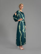Side view. Full length 100% silk tunic dress with light green macrosnake motif on teal colour, featuring a open, wide neckline and one side split on the skirt, gathered 3/4 length sleeves with a slash opening and optional ribbon belt.