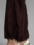 Ankle detail. Super lightweight 100% habutai silk pant in warm brown, with wide leg, drawstring gather at the ankle, a deep jersey waistband with a drawstring and patch pockets on the back.