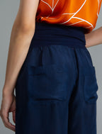 Pocket detail. Super lightweight 100% habutai silk pant in navy blue, with wide leg, drawstring gather at the ankle, a deep jersey waistband with a drawstring and patch pockets on the back.