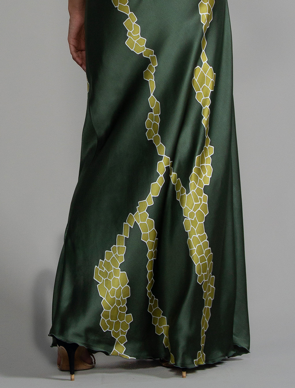 Motif detal: Elegant long body contouring silk dress in forest green colour with contrasting green graphic Macrosnake batik motif, featuring spaghetti straps, V-neckline and a fluid contemporary silhouette.