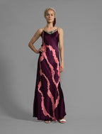 Front View. Elegant long body contouring silk dress in deep vino colour with contrasting pink graphic Macrosnake batik motif, featuring spaghetti straps, V-neckline and a fluid contemporary silhouette.