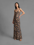 Front view. Elegant long body contouring silk dress in black colour with contrasting tobacco graphic Zebra batik motif, featuring spaghetti straps, V-neckline and a fluid contemporary silhouette.