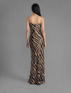 Back view. Elegant long body contouring silk dress in black colour with contrasting tobacco graphic Zebra batik motif, featuring spaghetti straps, V-neckline and a fluid contemporary silhouette.