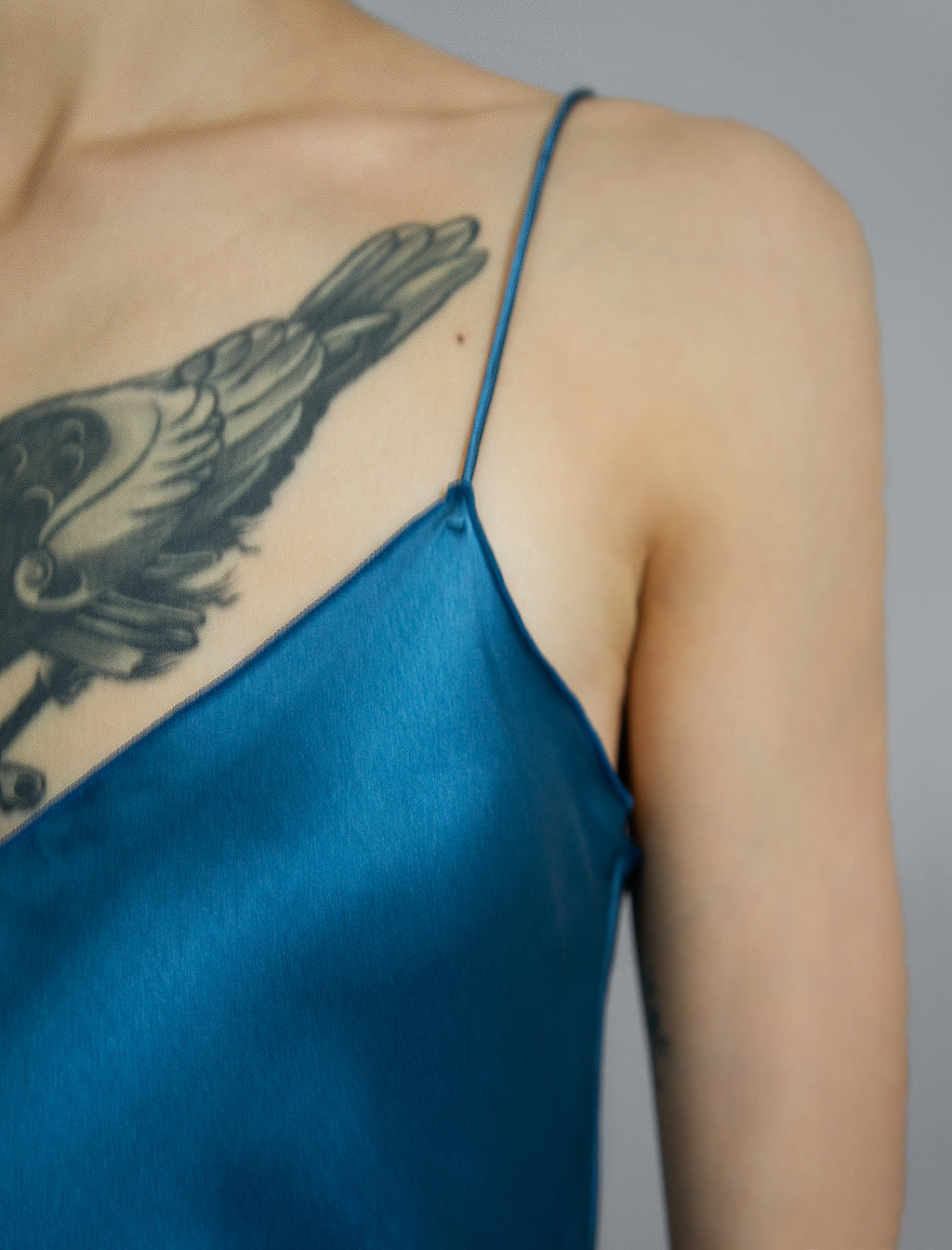 Strap and neckline detail: Elegant long body contouring silk dress in saxony blue colour with contrasting blue graphic Macrosnake batik motif, featuring spaghetti straps, V-neckline and a fluid contemporary silhouette.