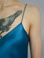 Strap and neckline detail: Elegant long body contouring silk dress in saxony blue colour with contrasting blue graphic Macrosnake batik motif, featuring spaghetti straps, V-neckline and a fluid contemporary silhouette.
