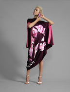 Front view 1. Elegant silk kaftan dress with oversized pink floral batik motif on deep vino colour silk, featuring flowing kimono sleeves, asymmetrical hemline, and relaxed contemporary silhouette.