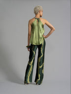 Back view. Long silk pants in forest green colour with contrasting blue graphic Macrosnake batik motif, featuring a knot tie at the front and a slick relaxed silhouette. 
