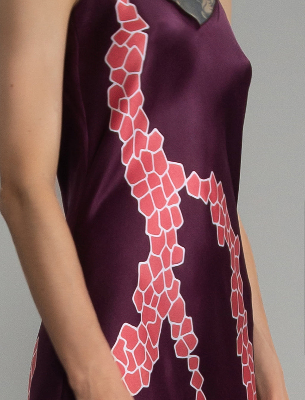 Motif detail: Elegant long body contouring silk dress in deep vino colour with contrasting pink graphic Macrosnake batik motif, featuring spaghetti straps, V-neckline and a fluid contemporary silhouette.
