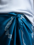 Knot detail: Long silk pants in saxony blue colour with contrasting blue graphic Macrosnake batik motif, featuring a knot tie at the front and a slick relaxed silhouette. 