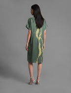 Back view. Mid length shirt dress in forest green colour with contrasting lime graphic Macrosnake batik motif, featuring short sleeves with deep hem, curved hemline, simple collar with narrow V-neckline and relaxed contemporary silhouette.