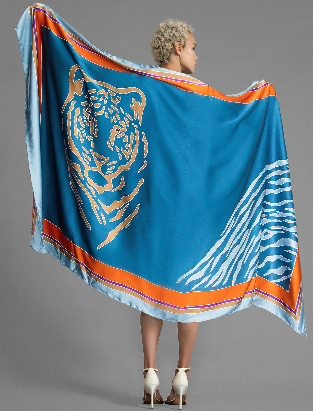 Detail view. Silk hand-crafted, hand-painted batik sarong in dream blue colour with gold tight and pale blue zebra motif.