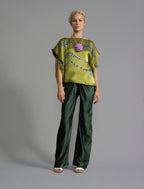 Variation 1. Flowing moss green colour silk top with graphic Macrosnake batik motif in contrasting green tone, featuring fluid draped sleeves, asymmetrical hemline, and versatile contemporary silhouette designed to be worn three ways.