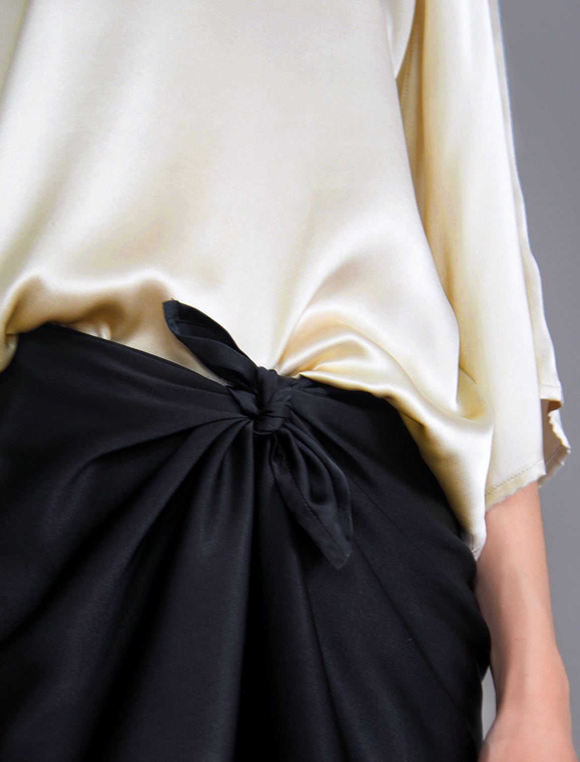 Knot detail. Long silk pants in black colour with tobacco tiger head batik motif, featuring a knot tie at the front and a slick relaxed silhouette. 