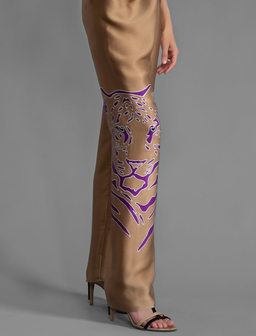 Motif detail. Long silk pants in tobacco colour with purple tiger head batik motif, featuring a knot tie at the front and a slick relaxed silhouette.