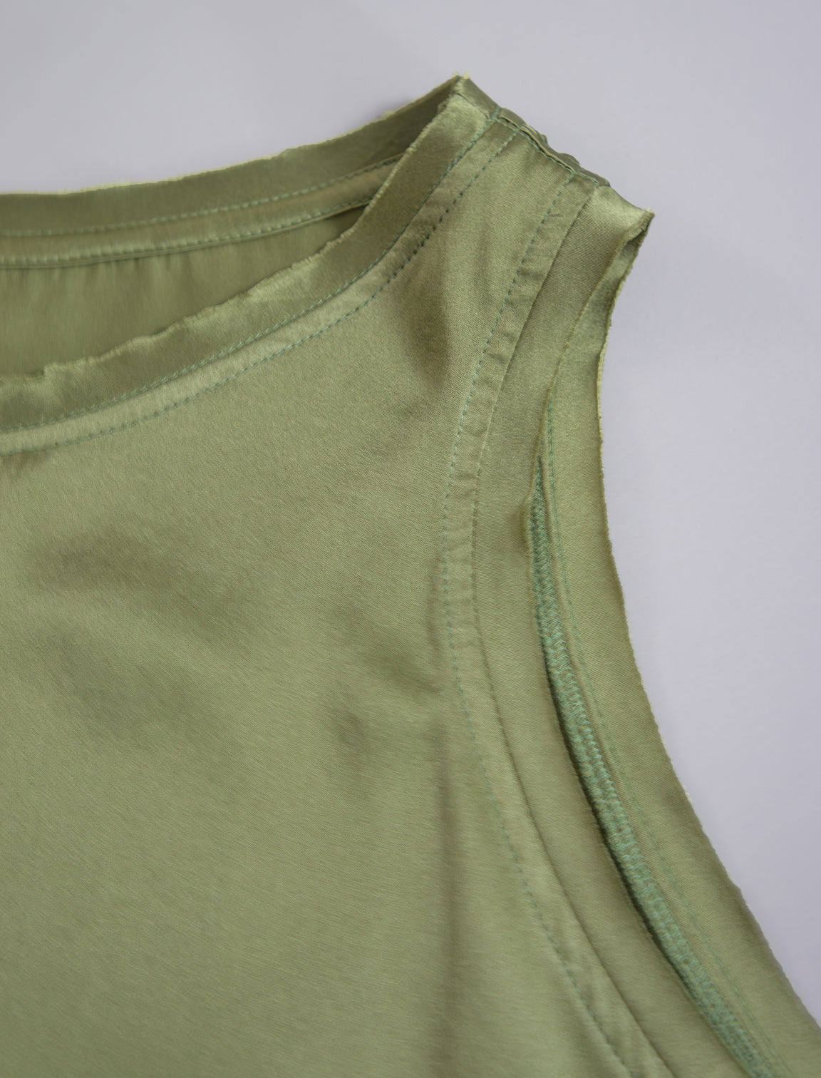 Detail view. Front view. 100% silk short length stretch singlet in fern green colour with open neckline and wide shoulder straps.