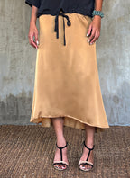 Quarzia Aline Skirt, flowing curved hemline gathered panel across the back-handcrafted from premium rayon. Plain Cashew-color crafted by artisans made in Bali.