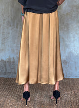 Load image into Gallery viewer, Back detail: Quarzia Aline Skirt, flowing curved hemline gathered panel across the back-handcrafted from premium rayon. Plain Cashew-color crafted by artisans made in Bali.
