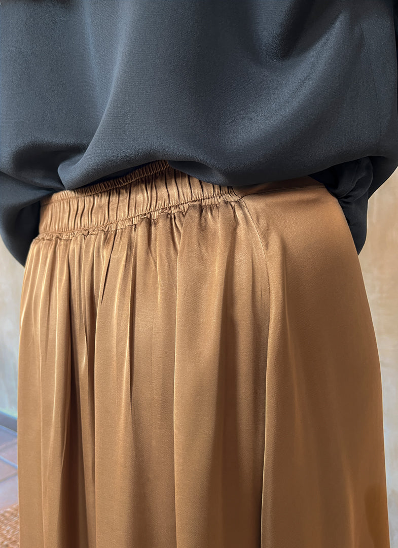 Back elasticated waist detail: Quarzia Aline Skirt, flowing curved hemline gathered panel across the back-handcrafted from premium rayon. Plain Cashew-color crafted by artisans made in Bali.