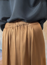 Load image into Gallery viewer, Back elasticated waist detail: Quarzia Aline Skirt, flowing curved hemline gathered panel across the back-handcrafted from premium rayon. Plain Cashew-color crafted by artisans made in Bali.
