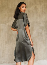 Load image into Gallery viewer, Side  detail: loose fit for the  Robi silk satin dress, with handpainted batik pattern of leafy branches in beige on grey background only in the front. The short sleeves , V-neckline  and 2 darts on the back body add a subtle structure to the soft and fluid silhouette.

