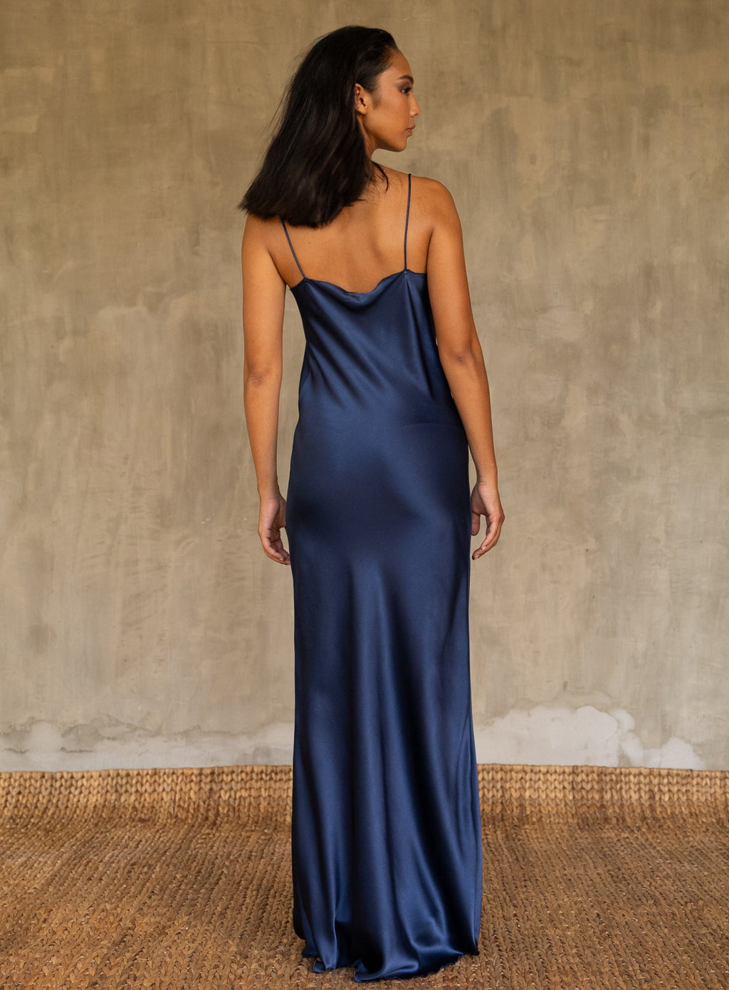 Back detail: this full length slip dress is cut on the bias, allowing a natural drape on the body which is complimented by the delicate spaghetti straps and the gentle, low-cut V-neckline. 