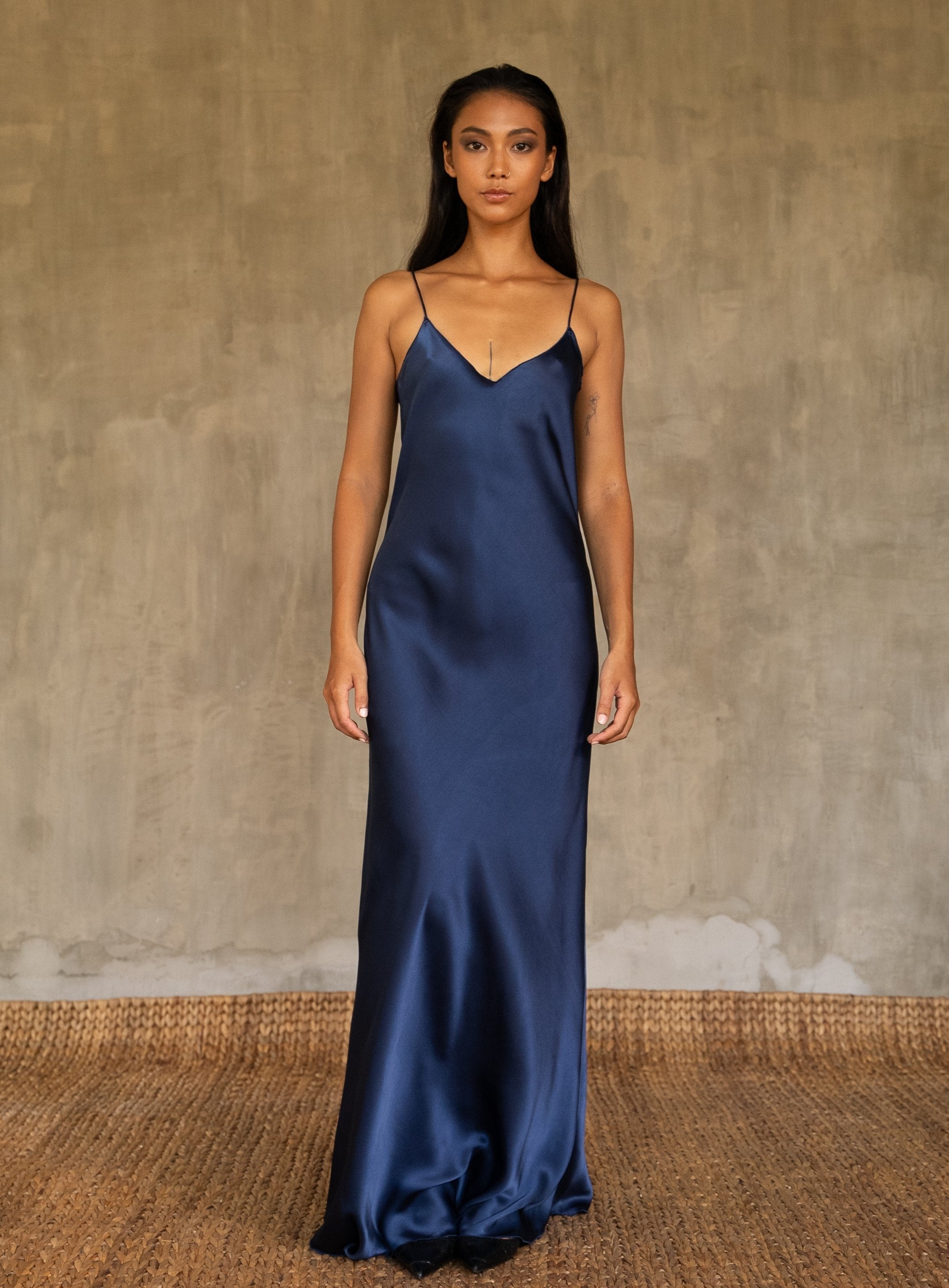 This full length slip dress is cut on the bias, allowing a natural drape on the body which is complimented by the delicate spaghetti straps and the gentle, low-cut V-neckline. 